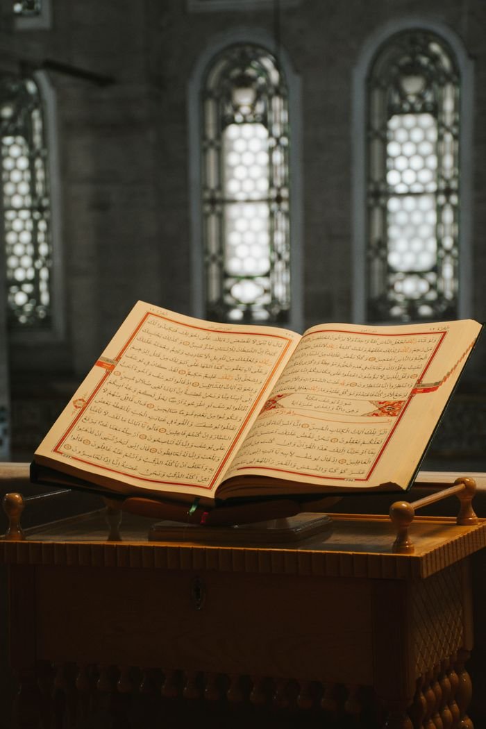 An open Quran on a wooden stand captures spiritual essence in a mosque.